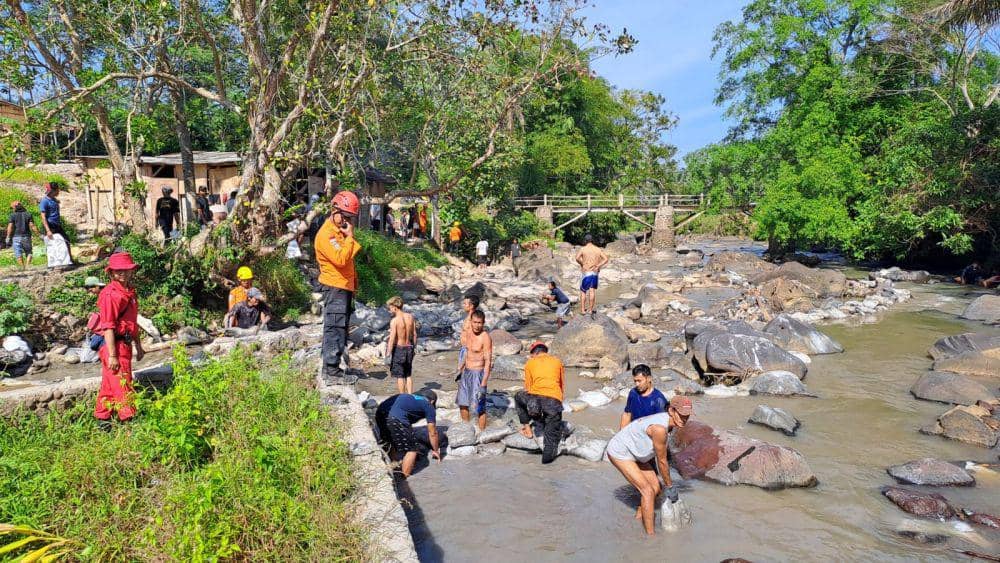 Tim SAR gabungan dibantu warga Desa Pancurendang Kecamatan Ajibarang bahu-membahu membendung aliran sungai yang dekat dengan lubang galian tambang emas yang runtuh. (IDN Times/Dok Humas Basarnas Cilacap)
