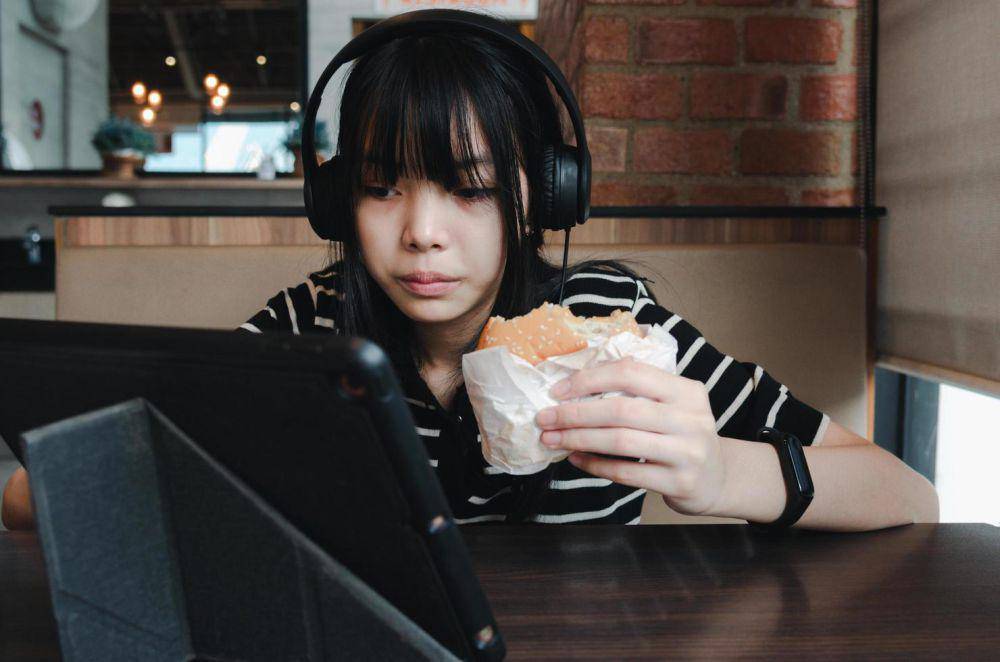 ilustrasi makan sambil nonton video (vecteezy.com/Khunkorn Laowisit)