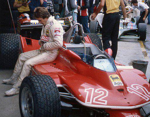 Gilles Villeneuve tengah duduk di samping Ferrari 312T4 miliknya di Sirkuit Imola pada 1979. (commons.wikimedia.org/ideogibs)