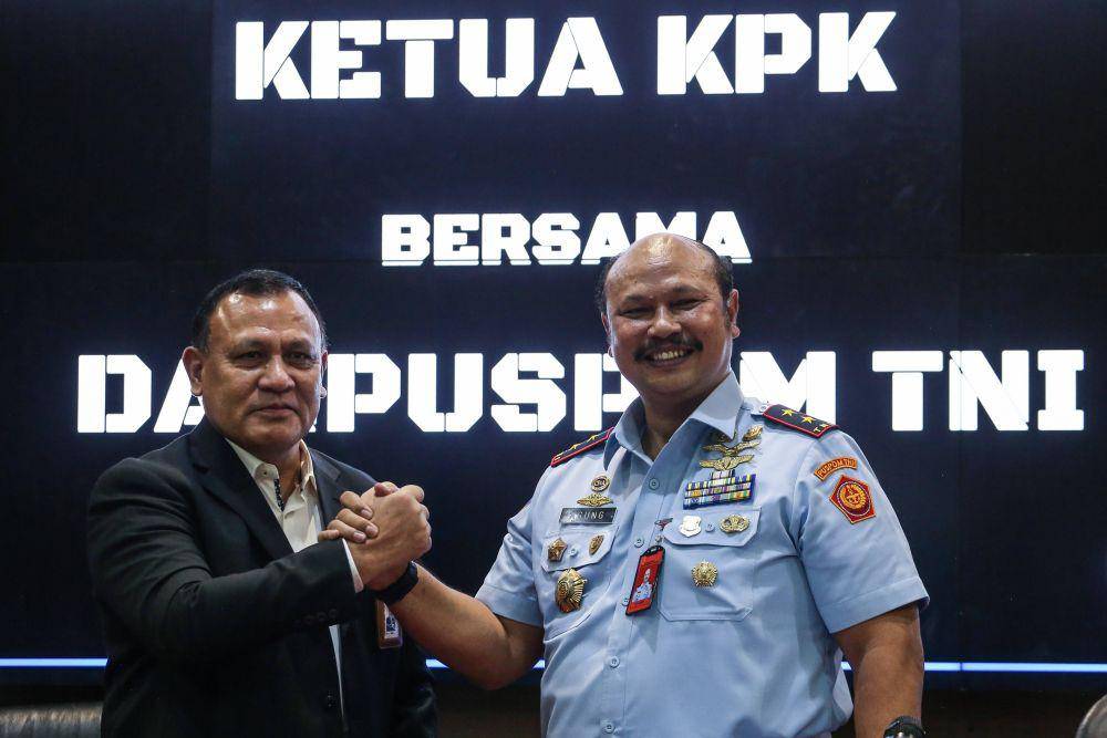 Danpuspom TNI Marsekal Muda Agung Handoko (kanan) bersama Ketua KPK Firli Bahuri (kiri) berjabat tangan usai konferensi pers terkait kasus dugaan korupsi Kabasarnas di Mabes TNI, Cilangkap, Jakarta, Senin (31/7/2023). (ANTARA FOTO/Asprilla Dwi Adha)
