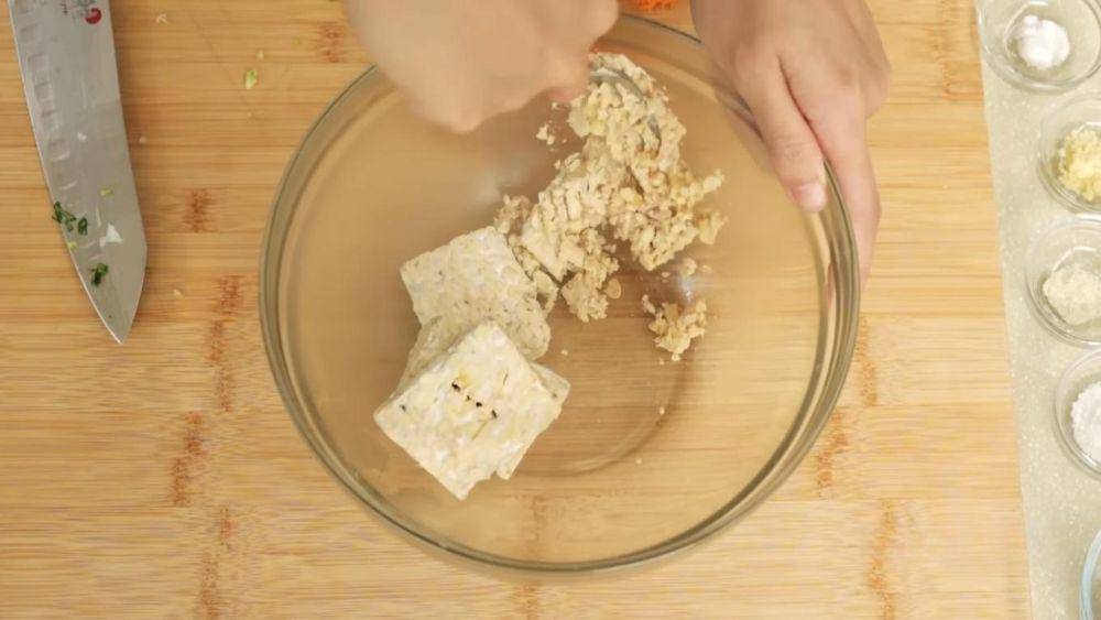 Proses menghancurkan tempe. (YouTube.com/Devina Hermawan)