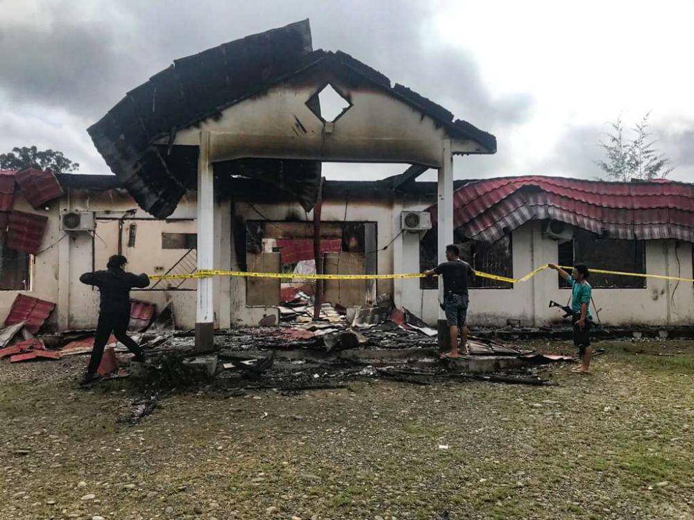 Aparat memasang garis polisi di lokasi terbakarnya Kantor KPU Distrik Dekai, Kabupaten Yahukimo, Papua Pegunungan, Minggu (6/8/2023). (IDN Times/Istimewa)