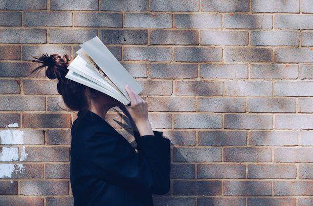 ilustrasi menutupi muka dengan buku (pexels.com/Siora Photography)