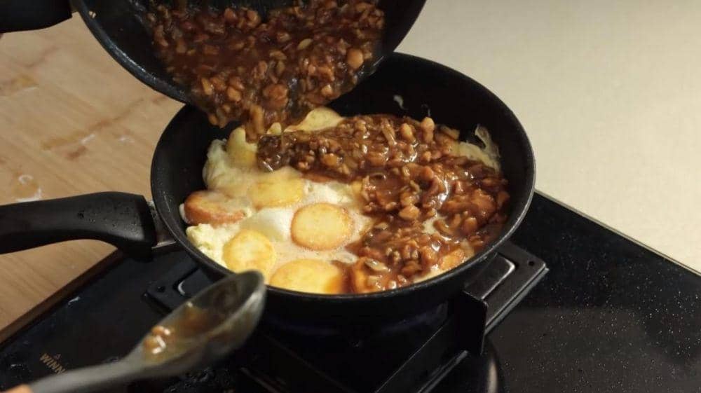 Proses menyiram dengan tumisan ayam jamur. (dok. YouTube.com/Devina Hermawan)