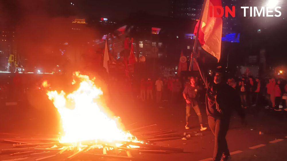 Ribuan buruh yang masih bertahan hingga malam hari mulai membakar kayu saat berdemo pada Kamis (10/8/2023). (IDN Times/Dini Suciatiningrum)