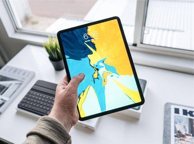 sebuah tablet sedang dipegang oleh seseorang (unsplash.com/@henryascroft)