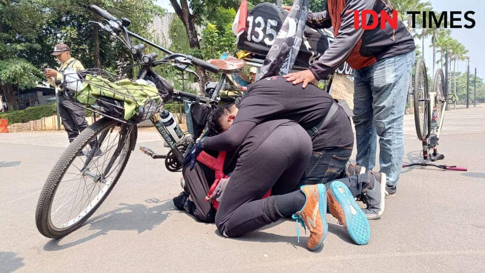 Pak Midun menangis di sepedanya. (IDN Times/Tino).