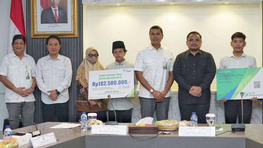 Pemberian santunan manfaat perlindungan dan beasiswa anak kepada ahli waris petugas haji yang meninggal senilai total Rp183 juta yang diserahkan langsung oleh Menteri Agama Republik Indonesia Yaqut Cholil Qoumas bersama Direktur Utama BPJS Ketenagakerjaan Anggoro Eko Cahyo, Selasa (15/8). (Dok. BPJAMSOSTEK)