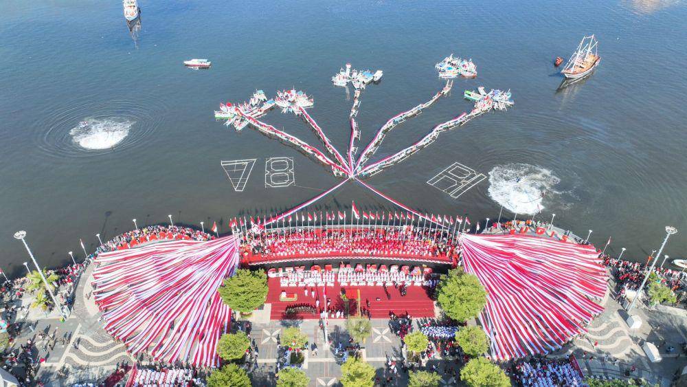 Pembentangan bendera berkonsep bunga rampai di Anjugan Pantai Losari Makassar, Kamis (17/8/2023), untuk memeriahkan upacara peringatan HUT ke-78 Kemerdekaan Indonesia. (Dok. Humas Pemkot Makassar)