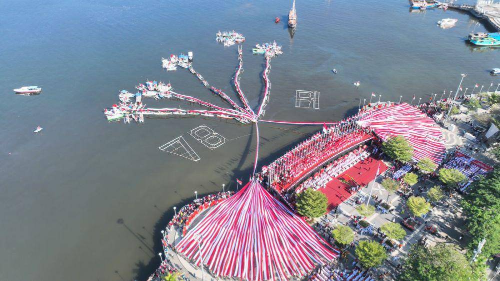Pembentangan bendera berkonsep bunga rampai di Anjugan Pantai Losari Makassar, Kamis (17/8/2023), untuk memeriahkan upacara peringatan HUT ke-78 Kemerdekaan Indonesia. (Dok. Humas Pemkot Makassar)