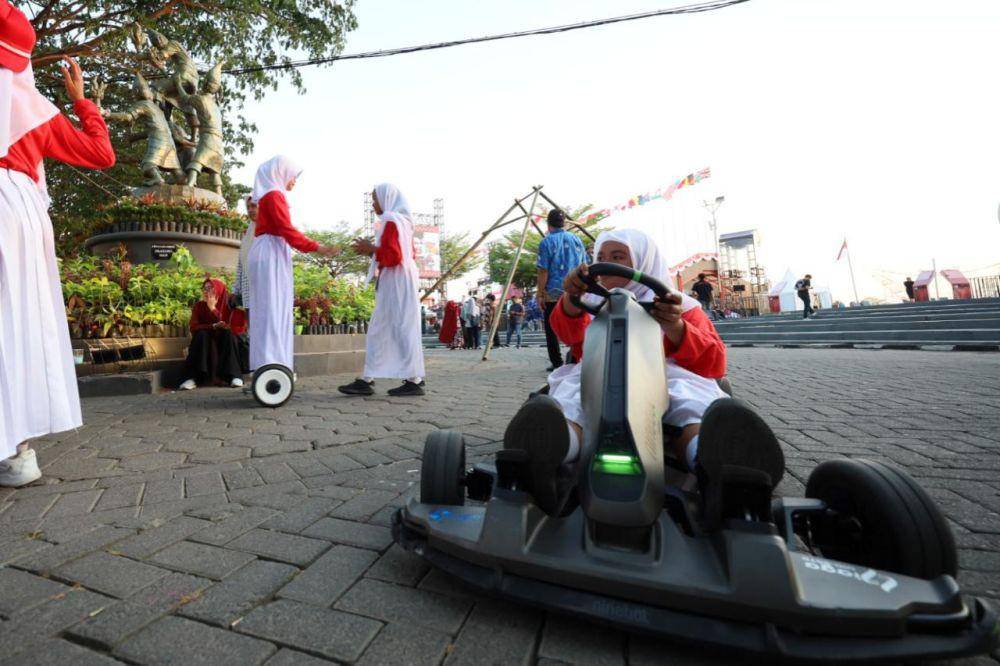 Pengunjung menjajal gokart dan hoverboard listrik yang disediakan di stan PLN pada festival F8 Makassar di Pantai Losari. (Dok. Istimewa)