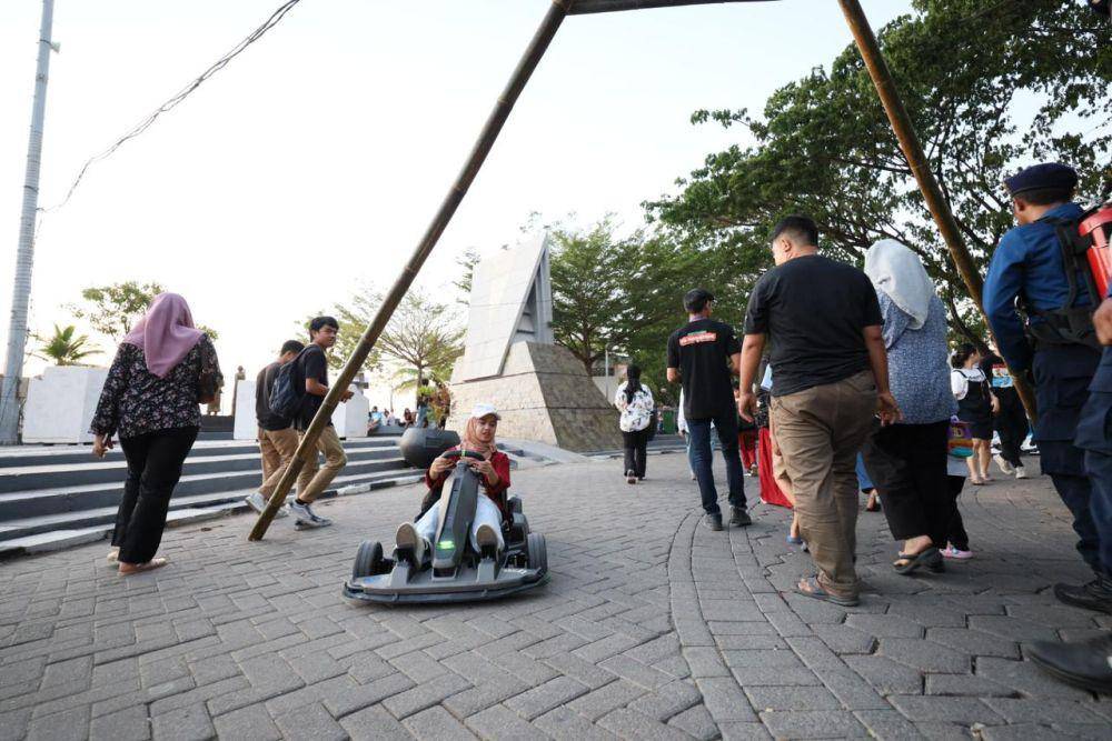 Pengunjung menjajal gokart listrik yang disediakan di stan PLN pada festival F8 Makassar di Pantai Losari. (Dok. Istimewa)