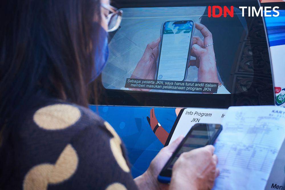 Warga memanfaatkan layanan BPJS Keliling untuk pendaftaran aplikasi mobile Jaminan Kesehatan Nasional (JKN) BPJS Kesehatan di kawasan Dispendukcapil Semarang, Kamis (20/7/2023). (IDN Times/Dhana Kencana)