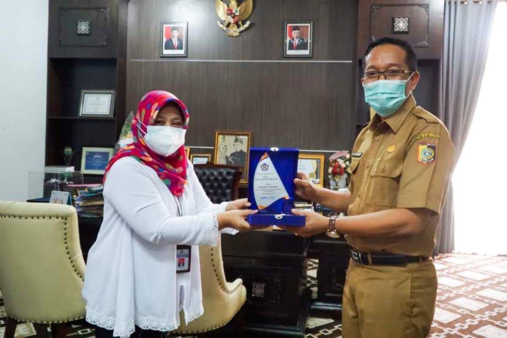Sekda Lotim menerima plakat penghargaan Kabupaten terbaik pengelolaan DAK Fisik 2022 dari KPP Pratama Selong (Dok. Humas Protokol Pemkab Lotim)