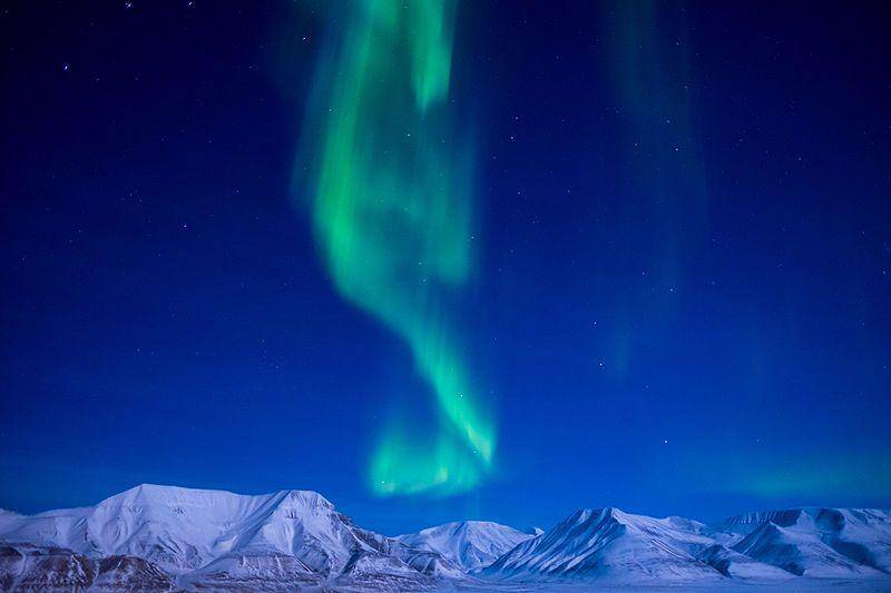 Aurora borealis muncul tepat di atas pegunungan es di Svalbard, Norwegia. (commons.wikimedia.org/Frode Ramone)
