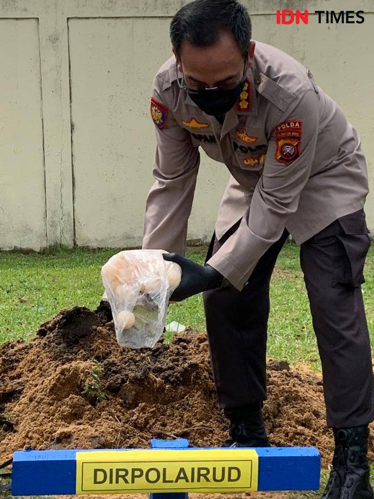 Direktur Polairud Polda Kalbar, Kombes Pol Raspani memusnahkan barang bukti telur penyu hijau dengan cara dikubur. (IDN Times/Istimewa).