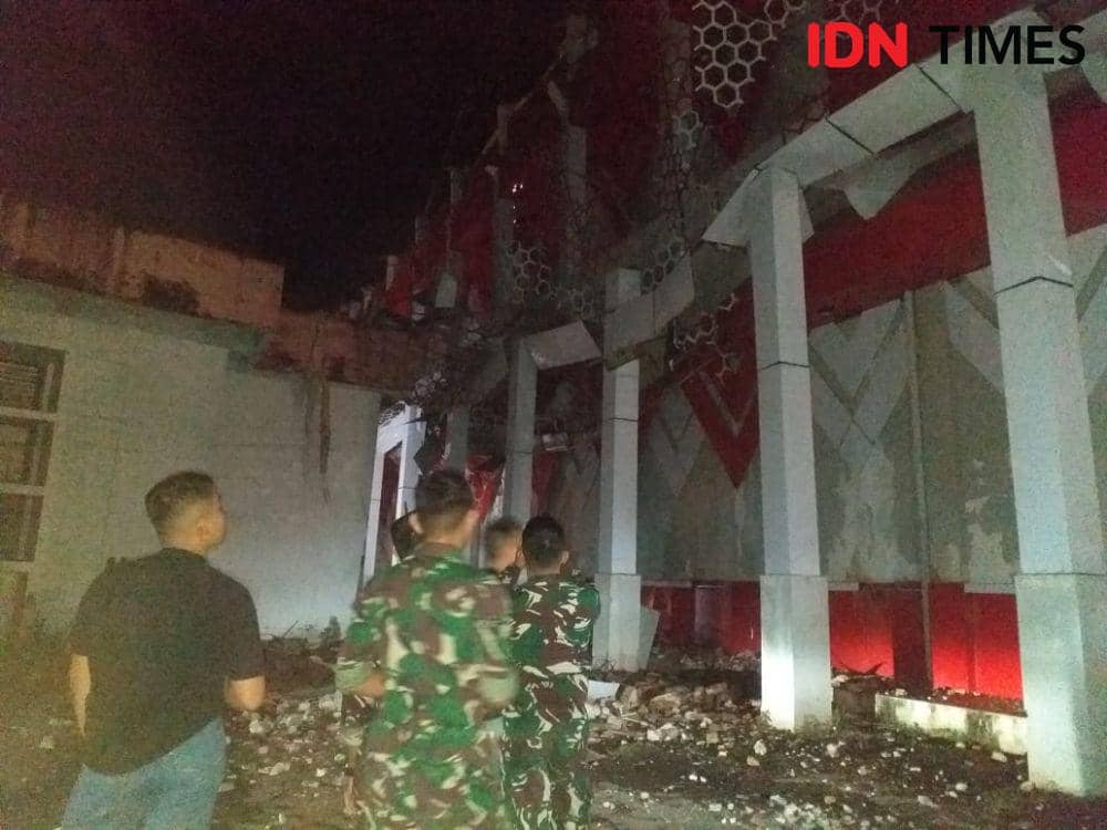 Warga dan TNI AD melihat kerusakan penampang luar Aula B GOR Wolter Monginsidi, Manado, Sulawesi Utara, yang rusak akibat gempa bumi tektonik berkekuatan Magnitudo 5,9, Senin (11/9/2023). IDNTimes/Savi