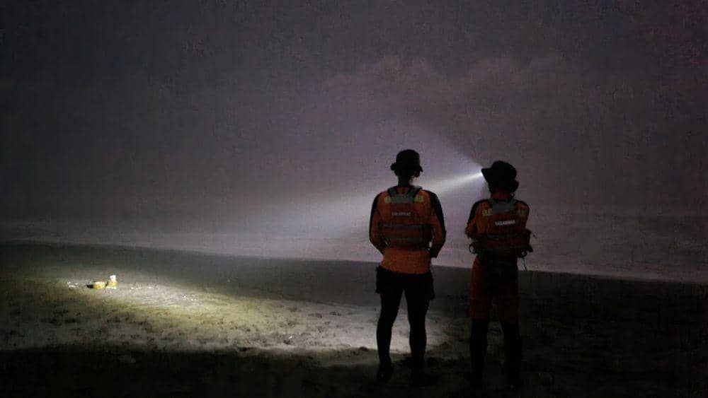Dua personel SAR gabungan terlihat menyoroti bibir Pantai Silumut dengan senter dengan harapan bisa menemukan jejak terakhir nelayan yang tenggelam. (IDN Times/Dok Humas Basarnas Cilacap)