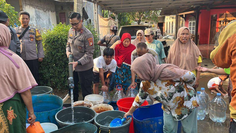 Kapolsek Bojongsari, Kompol Yefta Ruben H Arun saat memberikan air bersih kepada warga terdampak kekeringan, Kelurahan Duren Mekar, Bojongsari, Kota Depok. (Istimewa)