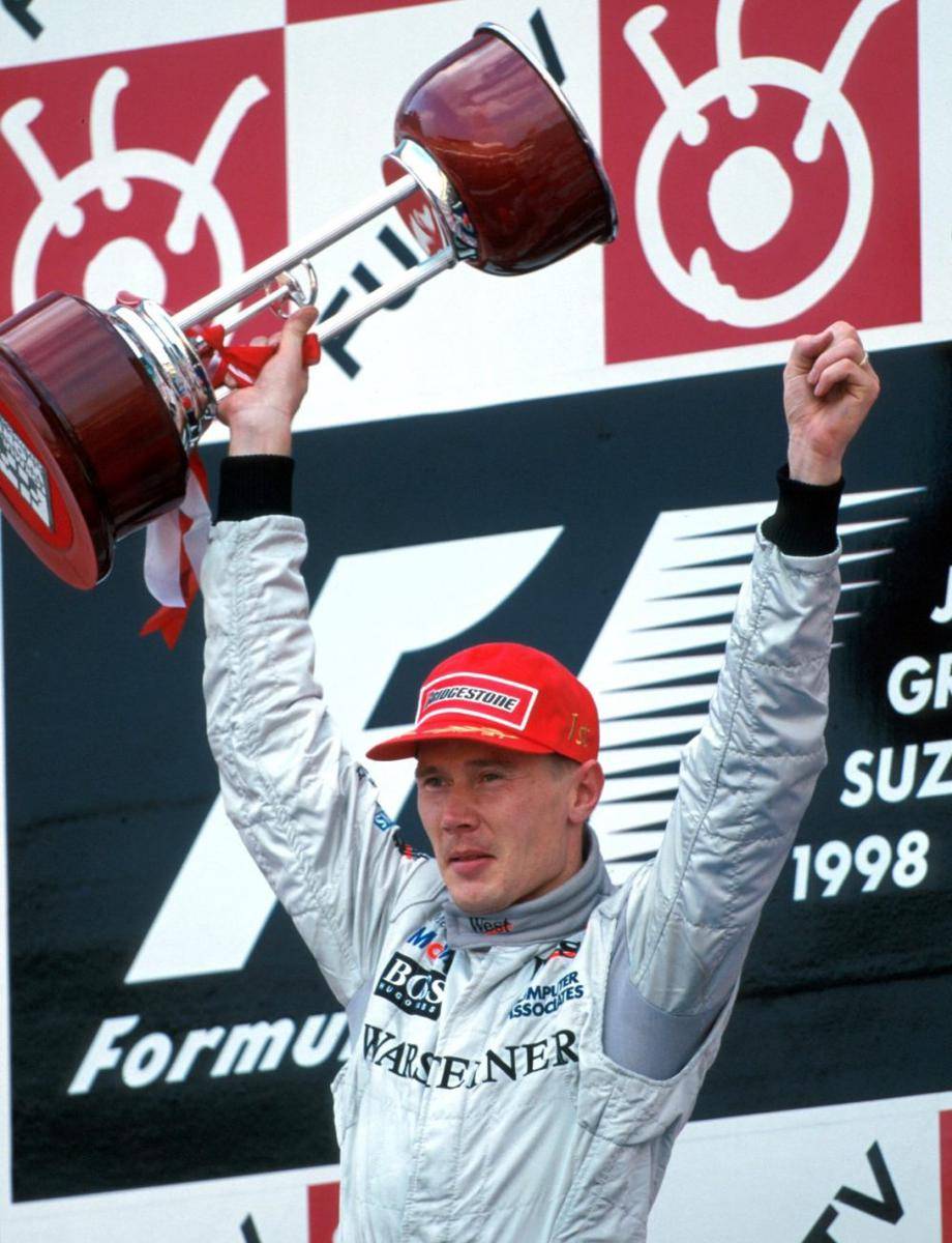 Mika Hakkinen mengangkat trofi kemenangan GP Jepang 1998 sekaligus meraih gelar juara dunia yang pertama di Formula 1. (facebook.com/McLaren)