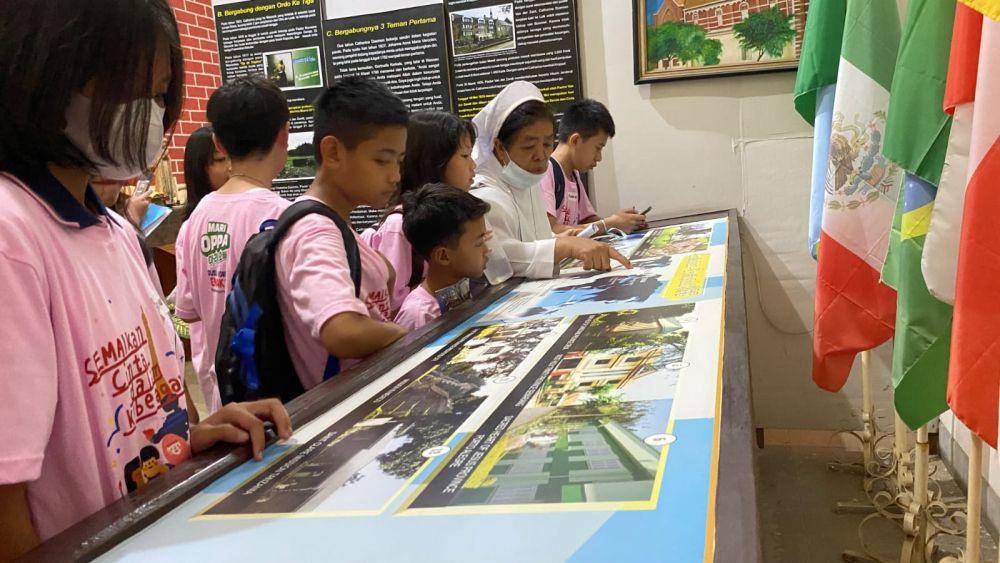 Beberapa anak terlihat mengamati dengan seksama panduan informasi yang diberikan seorang suster OSF saat melihat gambar mengenai sejarah Susteran Gedangan Semarang. (IDN Times/Dok Semai #4)