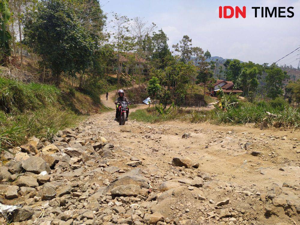 Pengendara Melintas Jalan di Desa Karyamukti, Kecamatan Cililin, KBB yang Rusak Parah. (Bangkit Rizki/IDN Times)