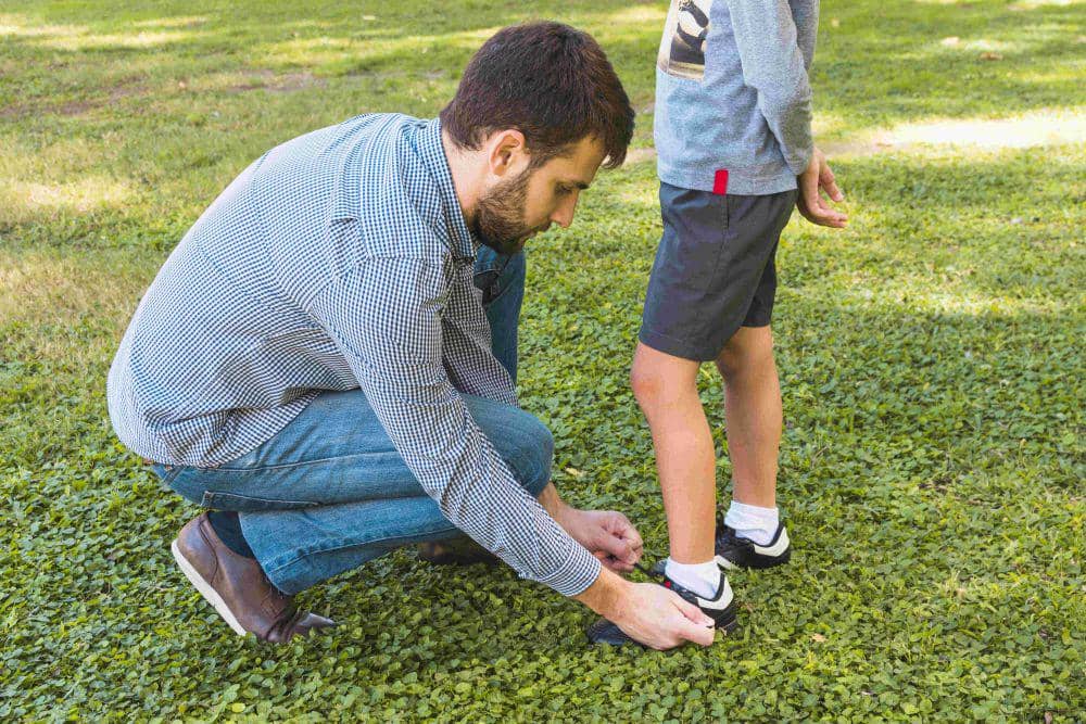 ilustrasi ayah mengikat tali sepatu anak (freepik.com/freepik)