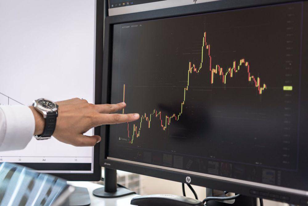 ilustrasi seseorang membaca grafik saham (pexels/AlphaTradeZone)