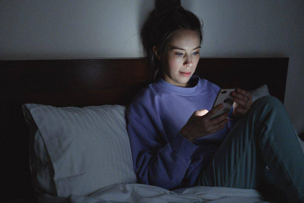 ilustrasi bermain ponsel sebelum tidur (pexels.com/SHVETS production)