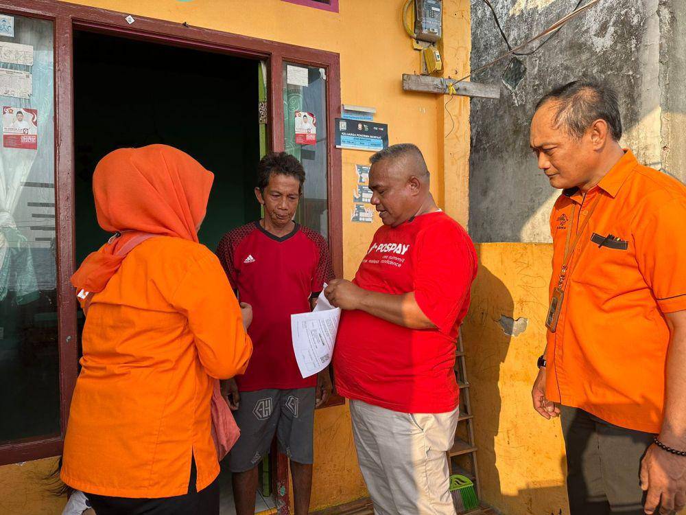 Penyerahan bantuan door to door dari Juru Bayar kepada penerima.  (Dok. Pos Indonesia)