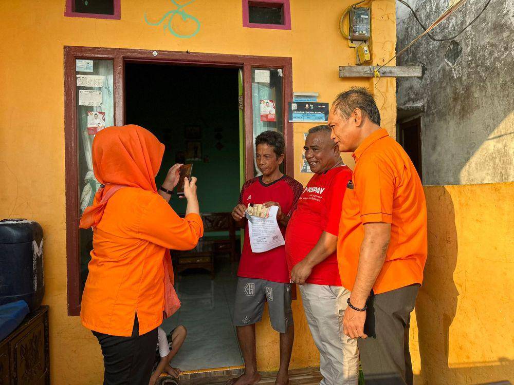 Penyerahan bantuan door to door dari Juru Bayar kepada penerima.  (Dok. Pos Indonesia)
