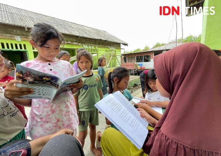 Antusiasme anak-anak Kampung Nelayan Seberang membaca buku karya mereka sendiri (IDN Times/Eko Agus Herianto)