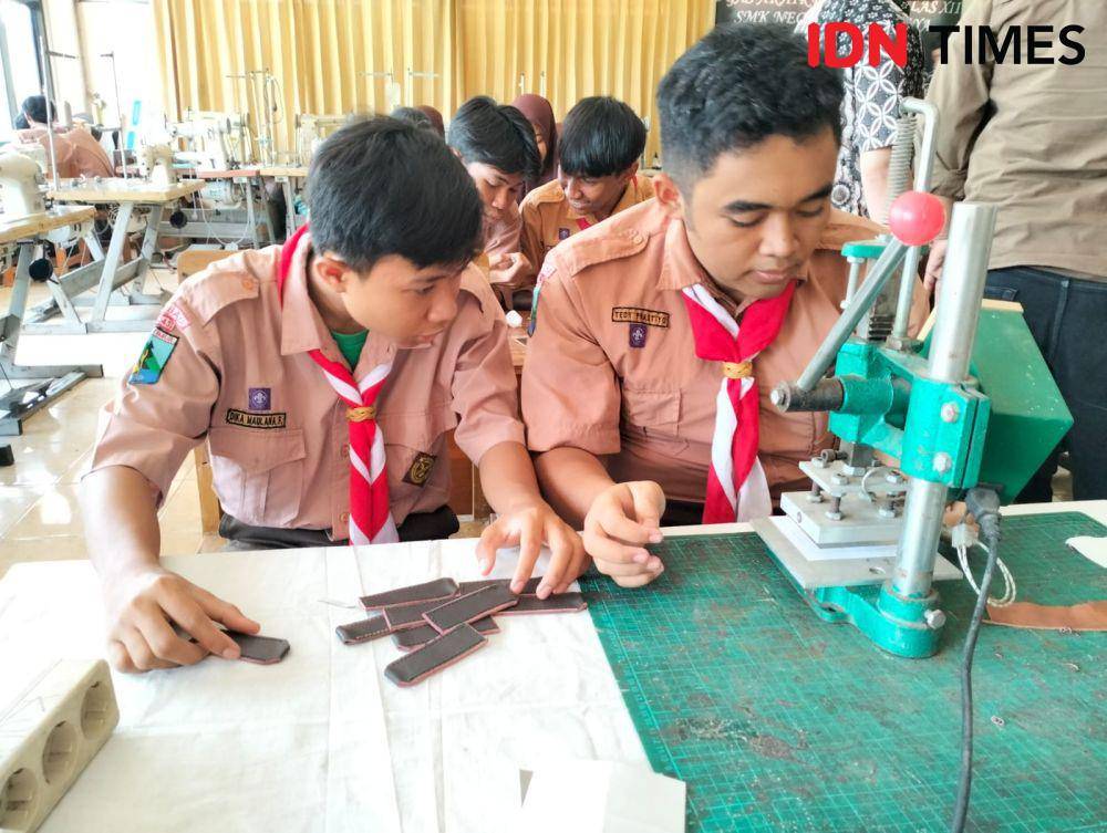 Siswa SMK Negeri 12 Surabaya saat memproduksi limbah kulit jadi gantungan kunci. (IDN Times/Khusnul Hasana)