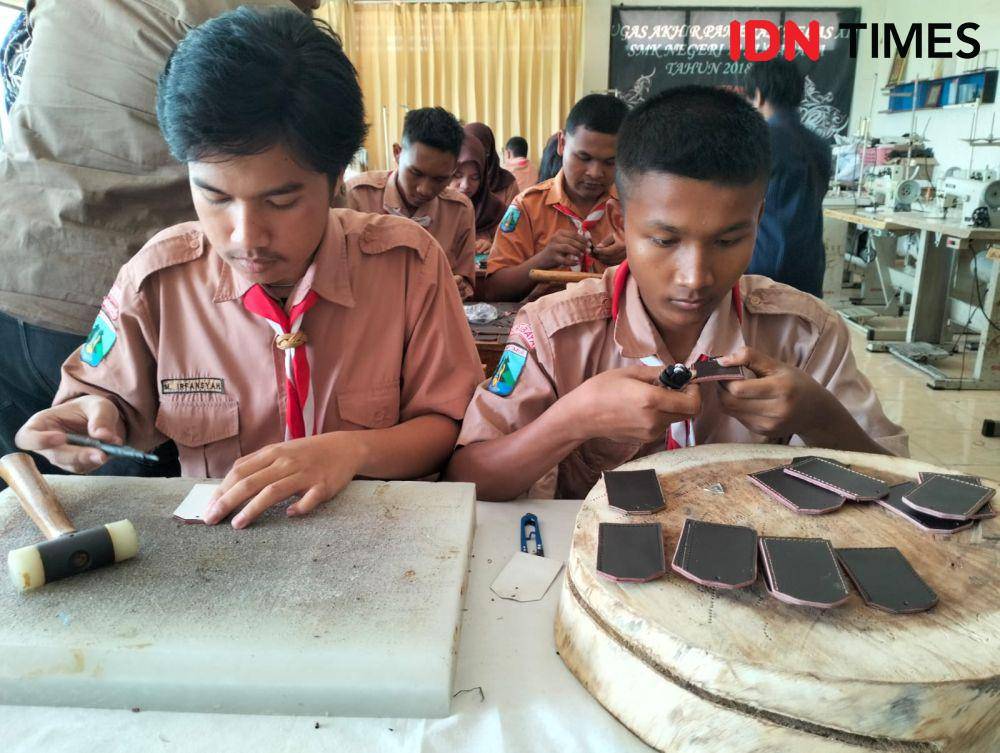 Siswa SMK Negeri 12 Surabaya saat memproduksi limbah kulit jadi gantungan kunci. (IDN Times/Khusnul Hasana)
