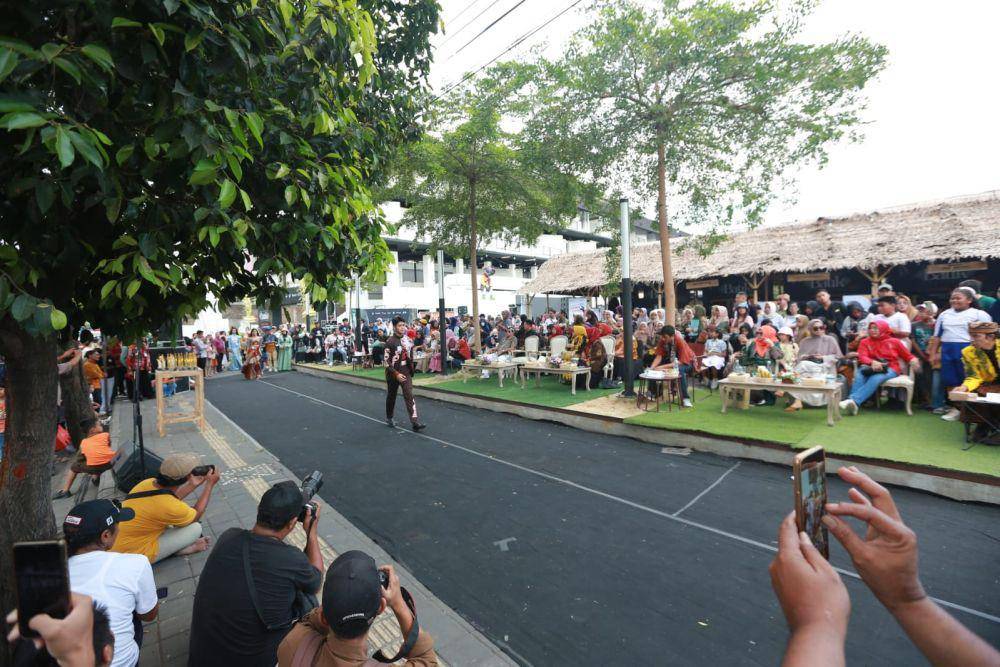 Puluhan peraga busana mengenakan batik berlenggak lenggok dengan menawan di sepanjang trotoar di depan area Banyuwangi Creative Hub yang berada di Terminal Pariwisata Terpadu, Banyuwangi. Para peraga tersebut tengah tampil dalam Fashion on Pedestrian yang digelar oleh Pemkab Banyuwangi, Jumat sore (20/10/2023). (Dok. Pemkab Banyuwangi)