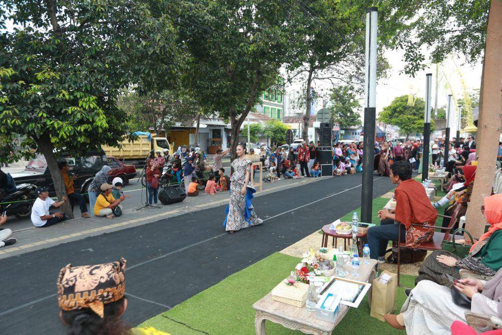 Puluhan peraga busana mengenakan batik berlenggak lenggok dengan menawan di sepanjang trotoar di depan area Banyuwangi Creative Hub yang berada di Terminal Pariwisata Terpadu, Banyuwangi. Para peraga tersebut tengah tampil dalam Fashion on Pedestrian yang digelar oleh Pemkab Banyuwangi, Jumat sore (20/10/2023). (Dok. Pemkab Banyuwangi)