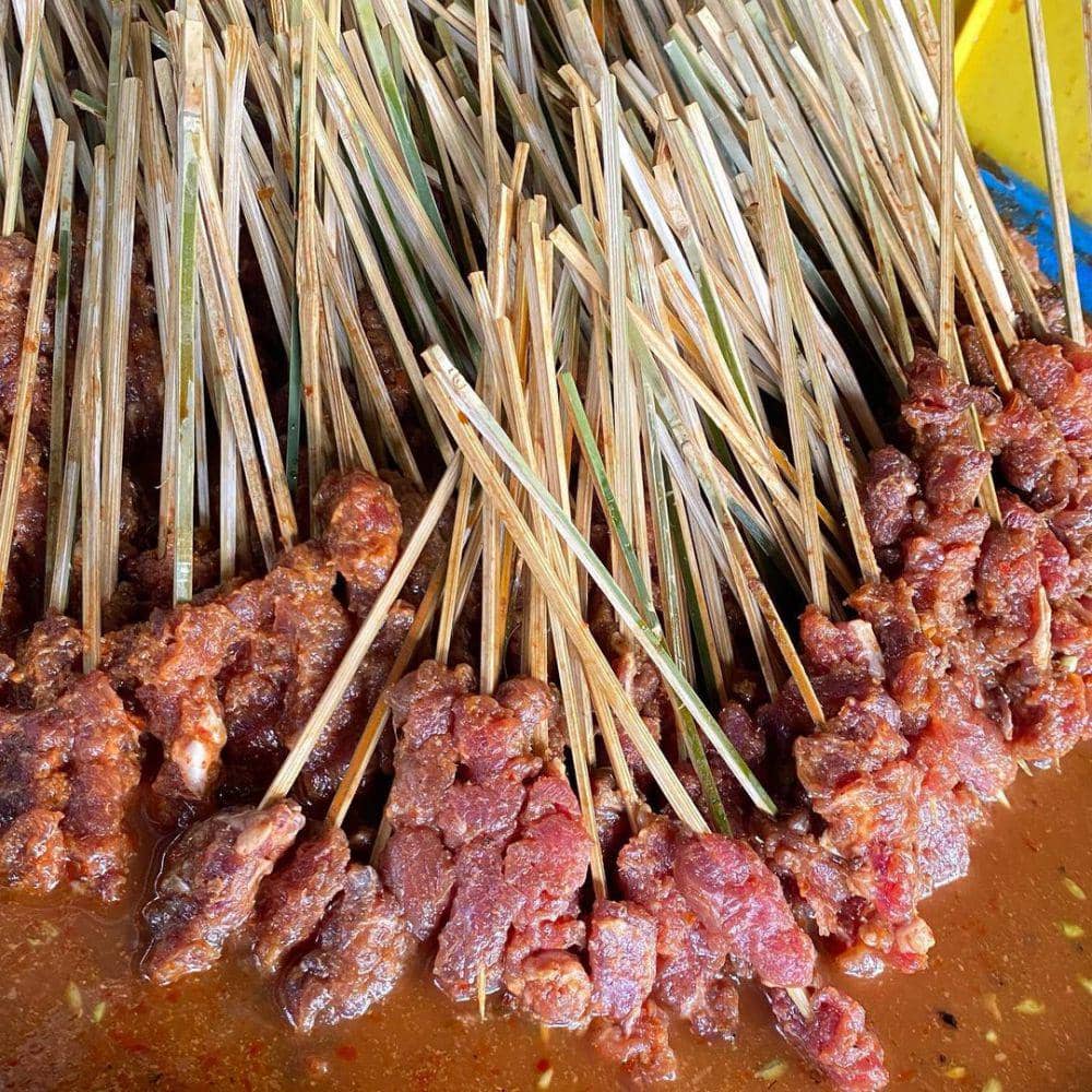 Tumpukan sate Rembiga yang hendak dicelupkan ke sambal (Instagram/kinomnom_)