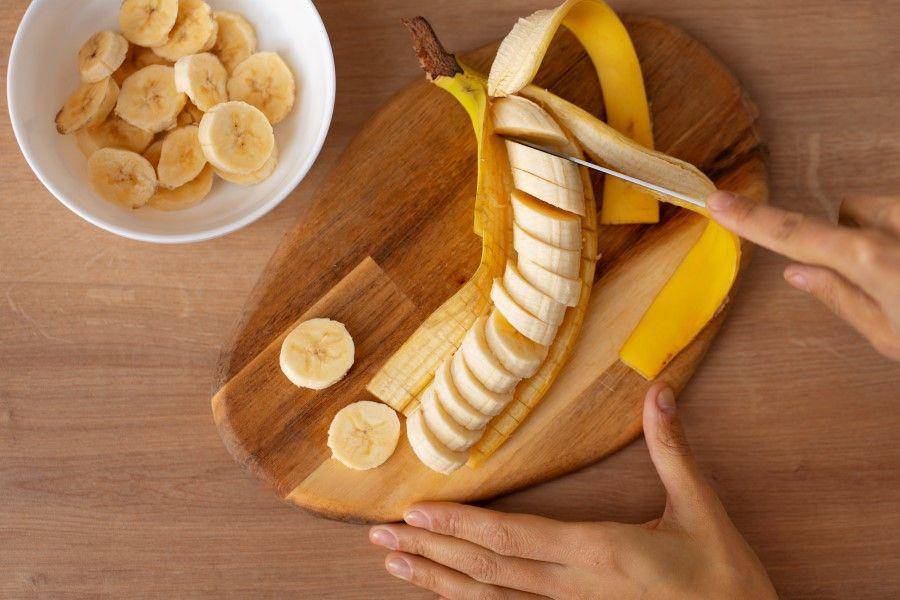 ilustrasi memotong buah pisang (freepik.com/Freepik)