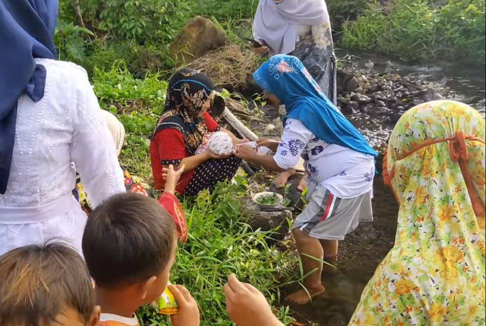 Prosesi pelaksanaan tradisi Turun Mandi. (YouTube.com/AZMI ELFA OFFICIAL)