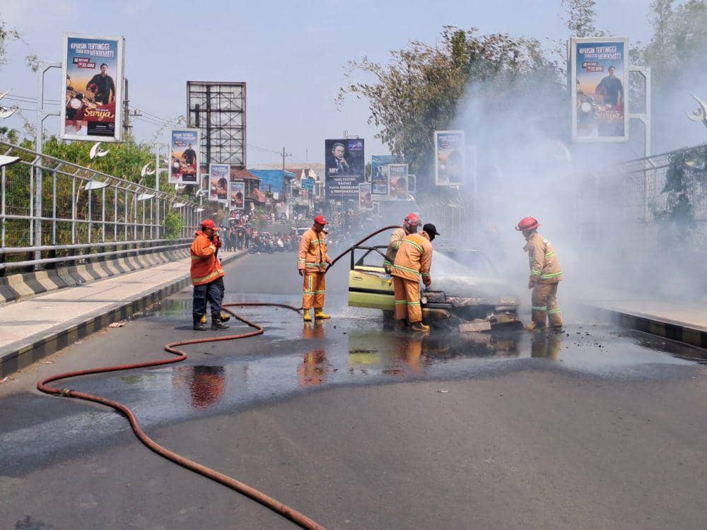 Petugas Damkar Kota Malang berusaha memadamkan api pada mobil di Jalan Ranugrati. (IDN Times/Rizal Adhi Pratama)