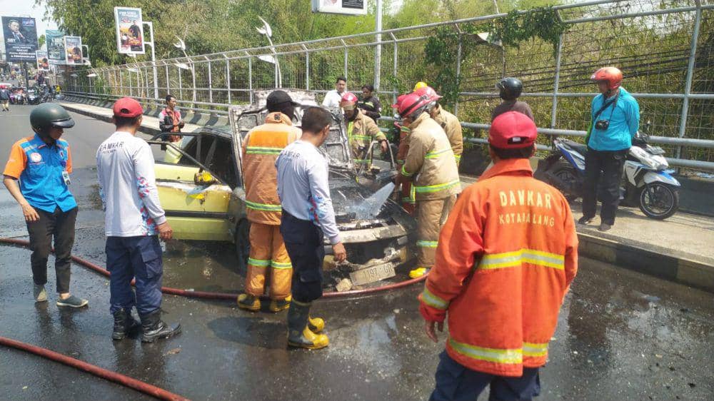 Petugas Damkar Kota Malang berusaha memadamkan api pada mobil di Jalan Ranugrati. (IDN Times/Rizal Adhi Pratama)