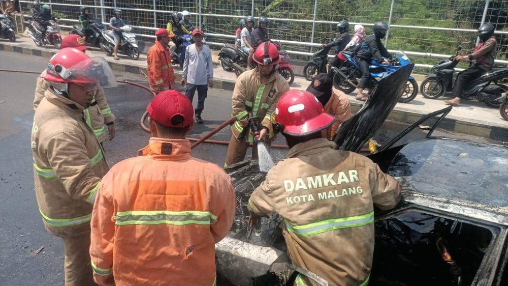 Petugas Damkar Kota Malang berusaha memadamkan api pada mobil di Jalan Ranugrati. (IDN Times/Rizal Adhi Pratama)