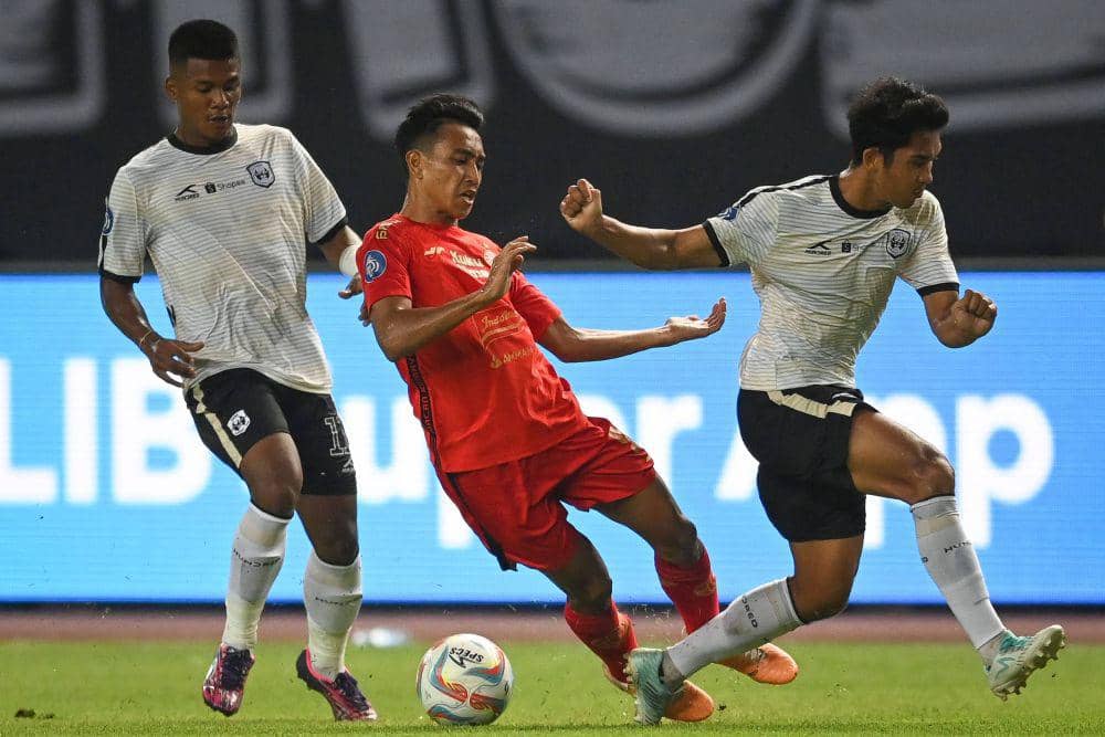 Pesepak bola Persija Jakarta Muhammad Hannan (tengah) terjatuh saat berusaha melewati dua pesepak bola Rans Nusantara dalam laga lanjutan putaran pertama Liga 1 2023-2024 di Stadion Patriot Chandrabhaga, Bekasi, Jawa Barat, Minggu (22/10/2023). ANTARA FOTO/Aditya Pradana Putra/nz