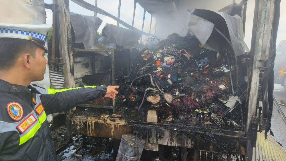 Pihak kepolisian saat memperlihatkan isi box truk ekspedisi JNE yang sudah hangus terbakar (IDN Times/ Fanny Rizano)