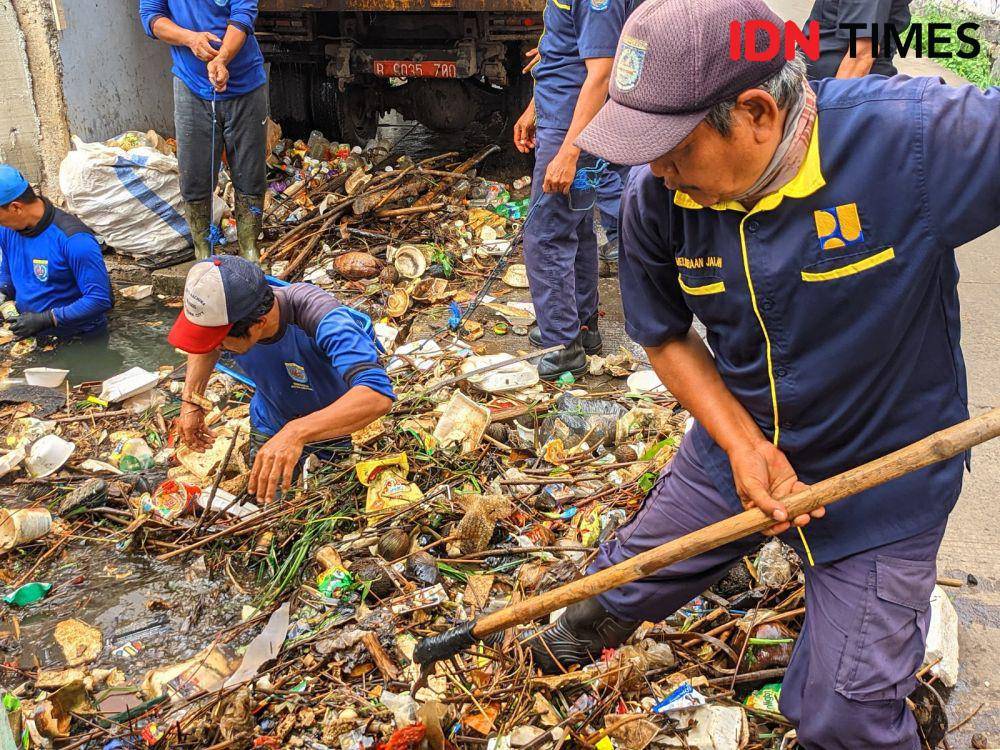 Satgas DPUPR Kota Depok membersihkan sampah yang menyumbat saluran air di wilayah Kota Depok. (IDNTimes/Dicky)