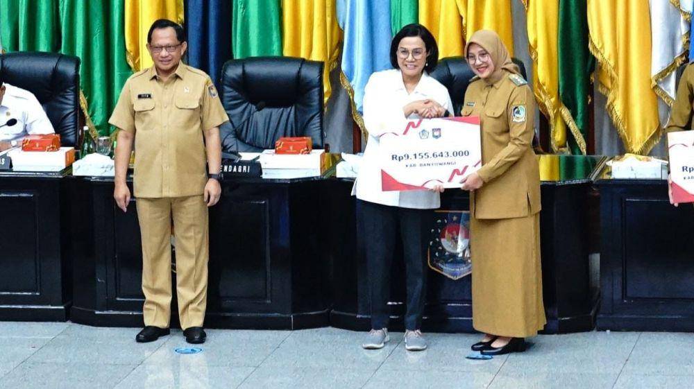 Menteri Keuangan Sri Mulyani, didampingi Menteri Dalam Negeri Tito Karnavian menyerahkan Dana Insentif Fiskal Kinerja (DIFK) senilai Rp9,15 miliar dari Kementerian Keuangan RI (Kemenkeu) kepada Bupati Banyuwangi Ipuk Fiestiandani. (dok. Pemkab Banyuwangi)