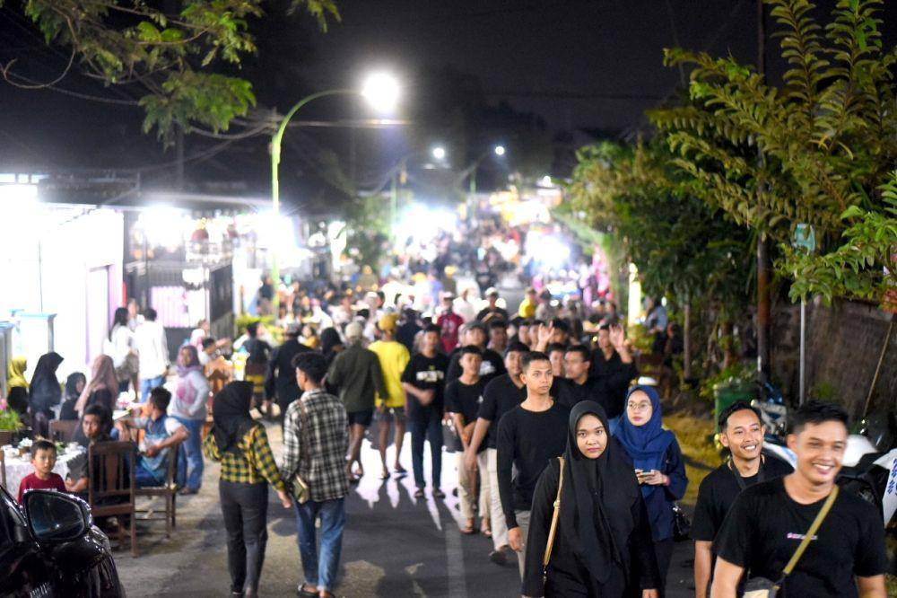 Ribuan orang memadati jalan utama Desa Kemiren untuk menikmati kopi yang disuguhkan masyarakat suku Osing, dalam tradisi Ngopi Sepuluh Ewu, di Desa Adat Kemiren Banyuwangi, Sabtu malam (4/11/2023). (Dok. Pemkab Banyuwangi)