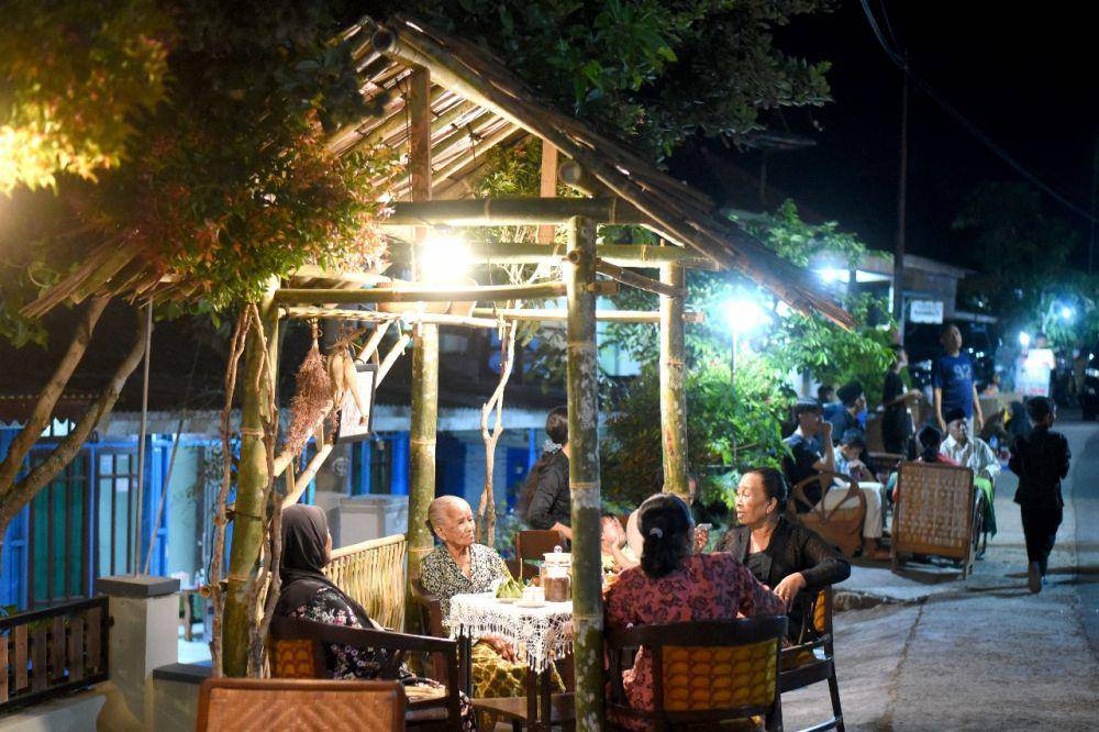 Ribuan orang memadati jalan utama Desa Kemiren untuk menikmati kopi yang disuguhkan masyarakat suku Osing, dalam tradisi Ngopi Sepuluh Ewu, di Desa Adat Kemiren Banyuwangi, Sabtu malam (4/11/2023). (Dok. Pemkab Banyuwangi)