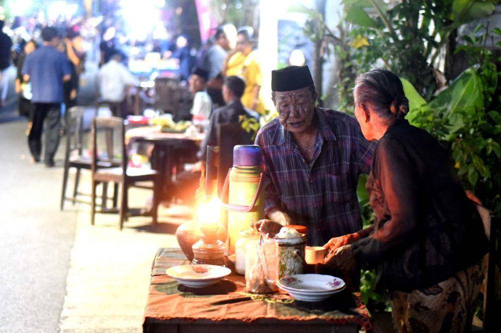 Ribuan orang memadati jalan utama Desa Kemiren untuk menikmati kopi yang disuguhkan masyarakat suku Osing, dalam tradisi Ngopi Sepuluh Ewu, di Desa Adat Kemiren Banyuwangi, Sabtu malam (4/11/2023). (Dok. Pemkab Banyuwangi)