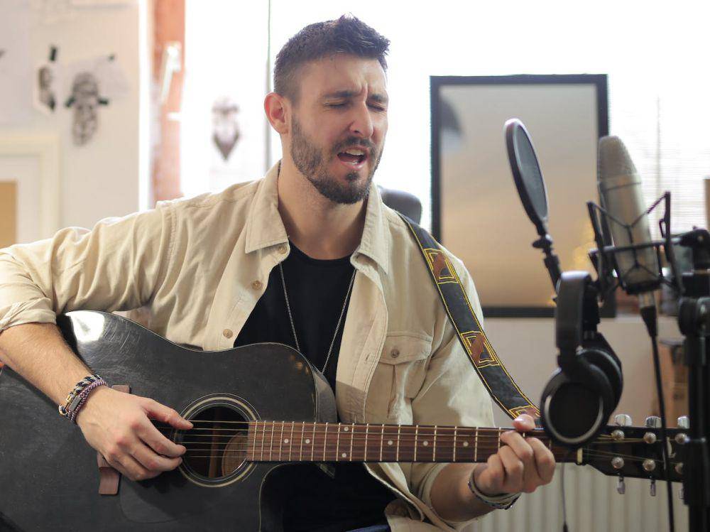 ilustrasi bernyanyi dan bermain gitar (pexels.com/Andrea Piacquadio)